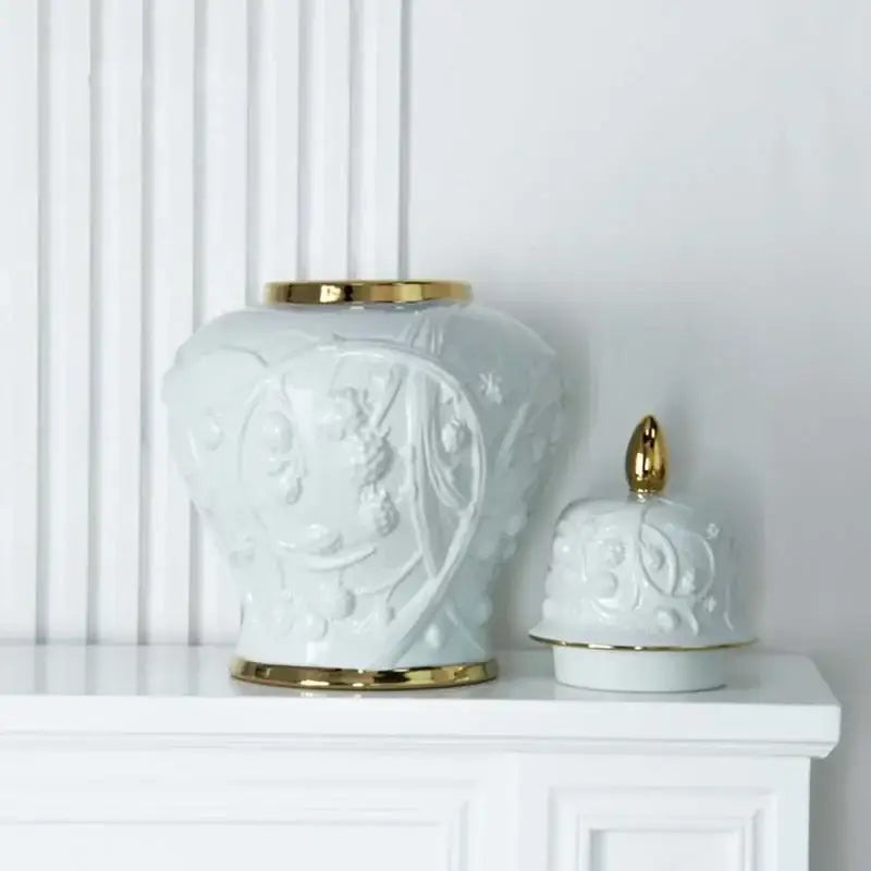 White ceramic ginger jar vase with embossed flower patterns and gold-trimmed lid and base for living room storage