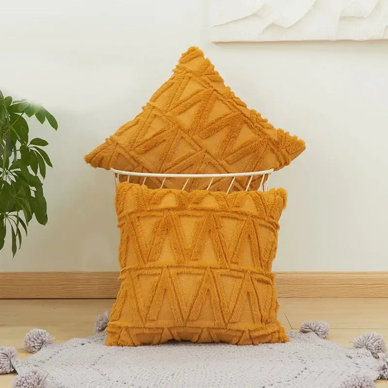 Warm mustard-yellow textured throw pillows with fringed edges complement white embroidered diamond cushion cover