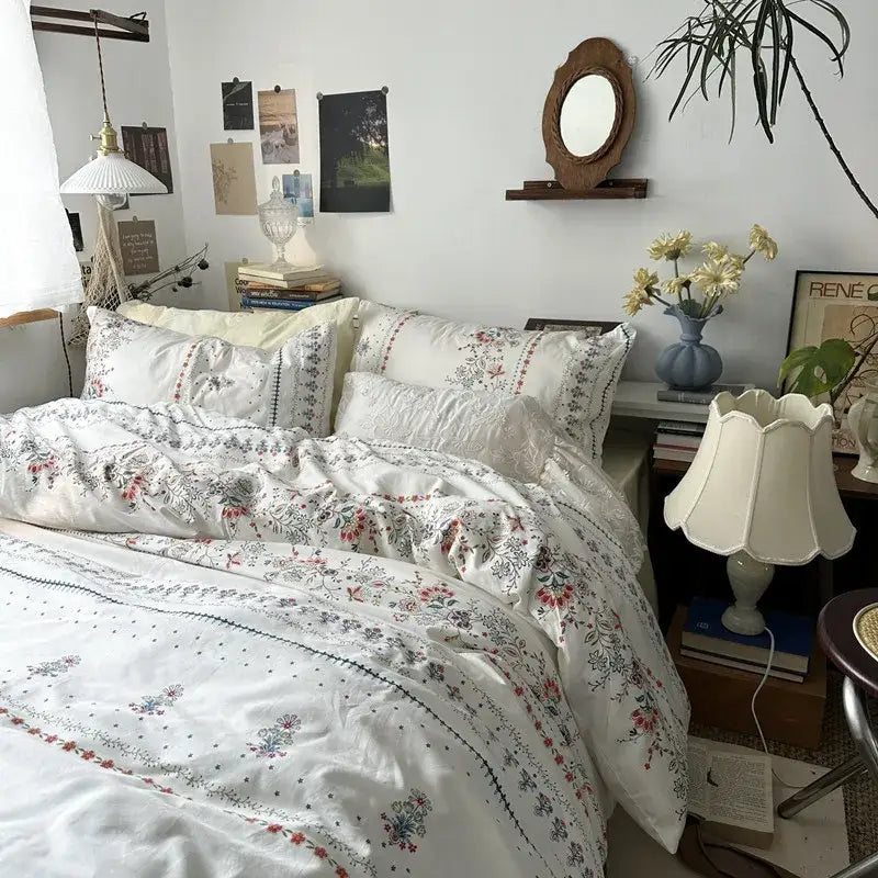 White floral embroidered cotton duvet cover set with delicate red and green botanical designs on soft textured fabric