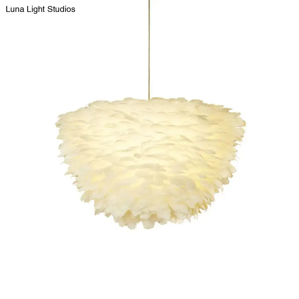 Soft cream-colored feather accents on a white floral pendant chandelier for elegant dining room lighting