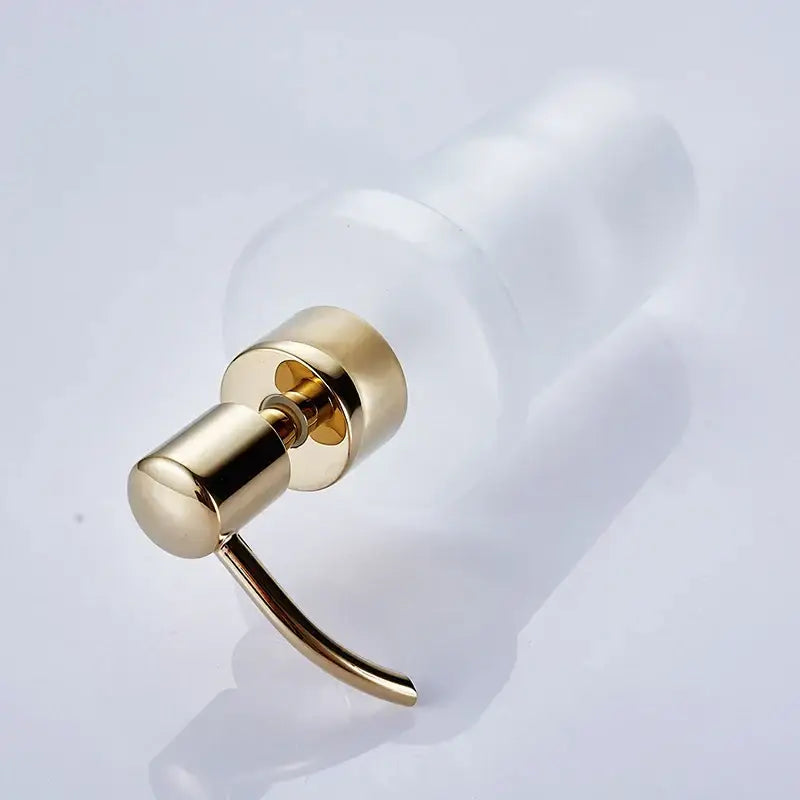 White frosted glass liquid soap dispenser with gold-toned metal pump for bathroom use as a liquid soap dispenser
