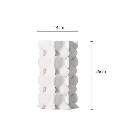 A tall white ceramic vase with a distinctive geometric ceramic fold pattern for living room decor by decorbites