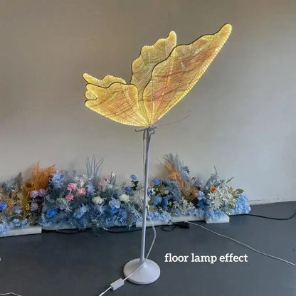 Golden butterfly chandelier stand with illuminated wings and slender metallic base for dining room use