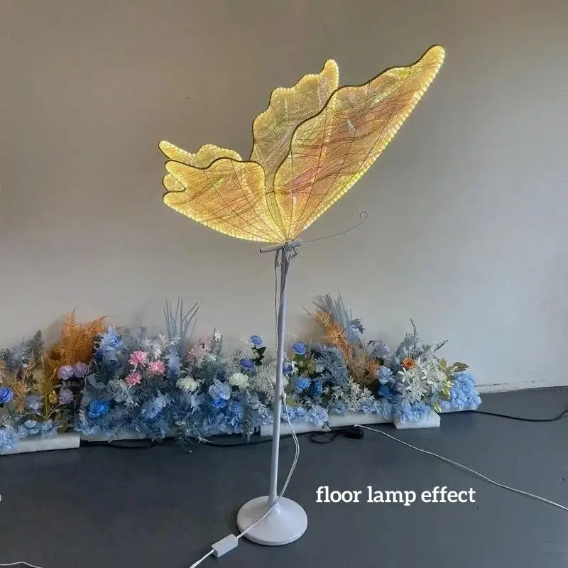 Golden butterfly chandelier stand with illuminated wings and slender metallic base for dining room use