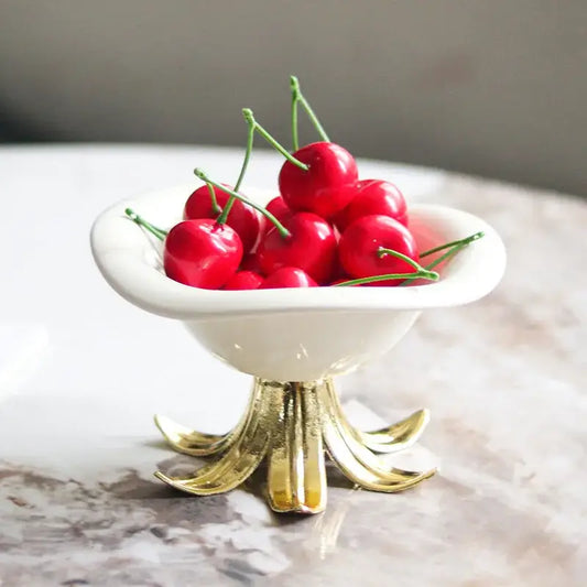 White and gold ceramic fruit plate tray bowl with a gold leaf pedestal base filled with bright red cherries