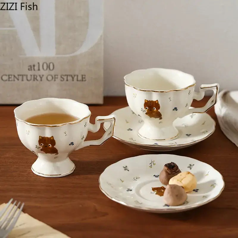 White ceramic teacups and saucers with gold trim featuring a cute brown cartoon kitten pattern for dining room use