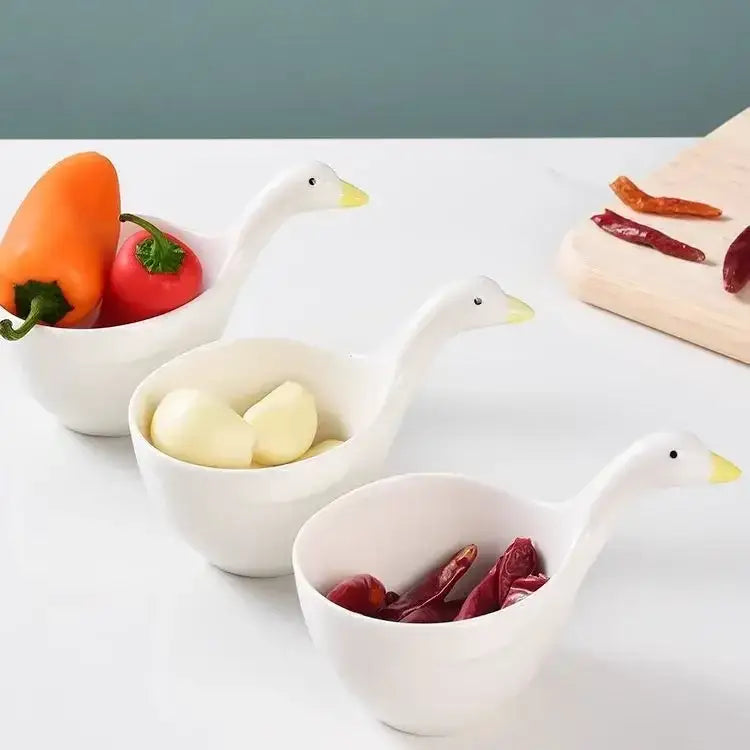 Three white goose ceramic snack bowls with yellow beaks hold different ingredients in a ceramic snack bowl set