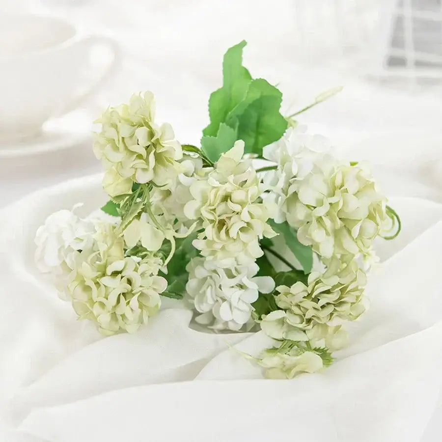 White hydrangea bouquet in ribbed glass vase with artificial flowers in soft white and pale green for decorbites decor