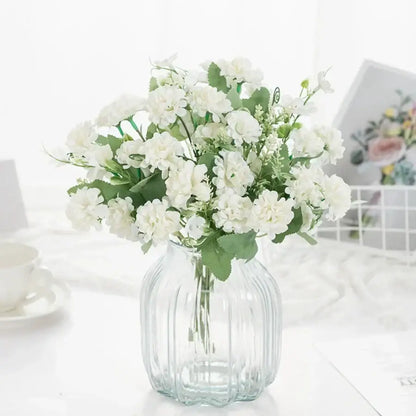 A clear ribbed glass vase with white artificial hydrangea bouquet and green leaves for living room decor by decorbites
