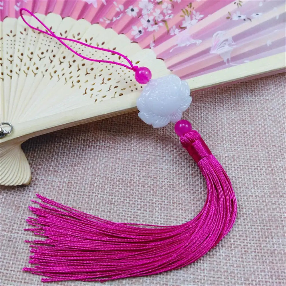 White jade lotus pendant with vibrant pink tassel and beads designed as an elegant decorative living room charm