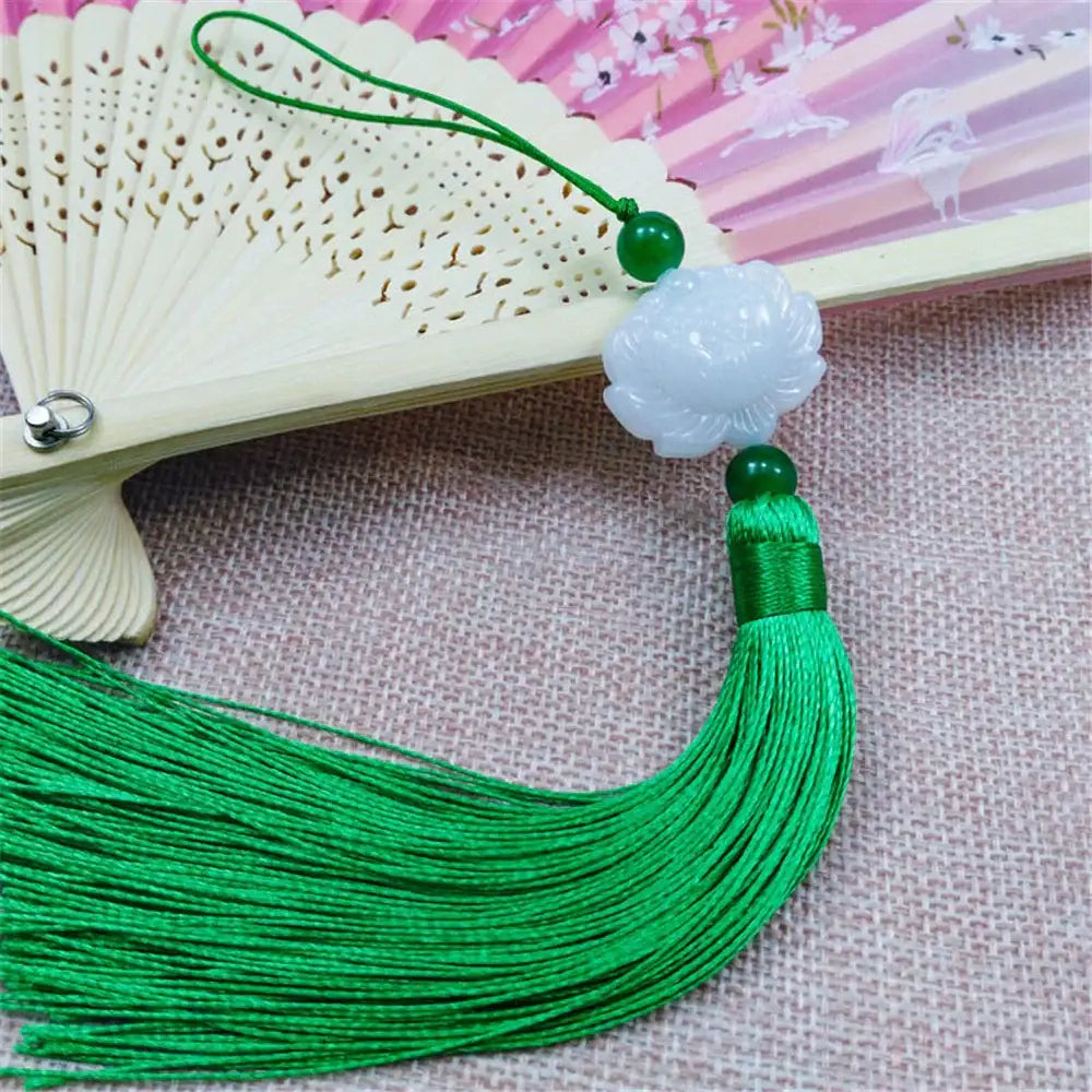 White jade lotus pendant with green silk tassel and beads attached to decorative fan for living room decor