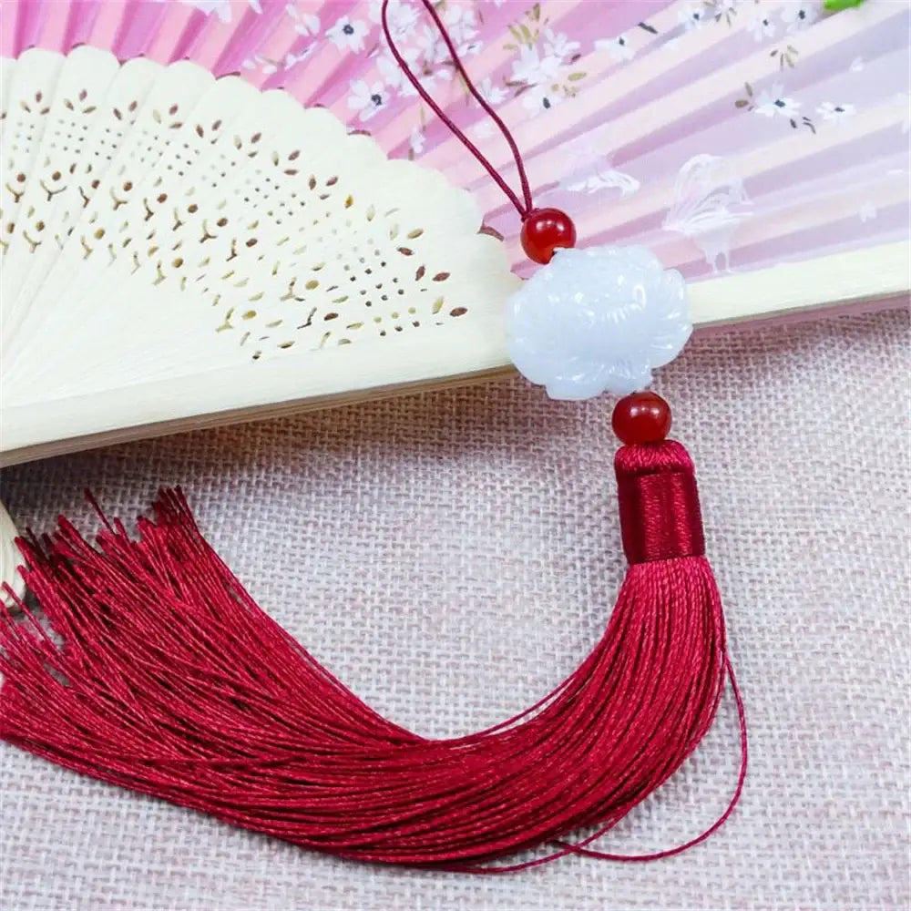 A white jade lotus decorative pendant featuring a cloud shape with red beads and a pink tassel for living room decor