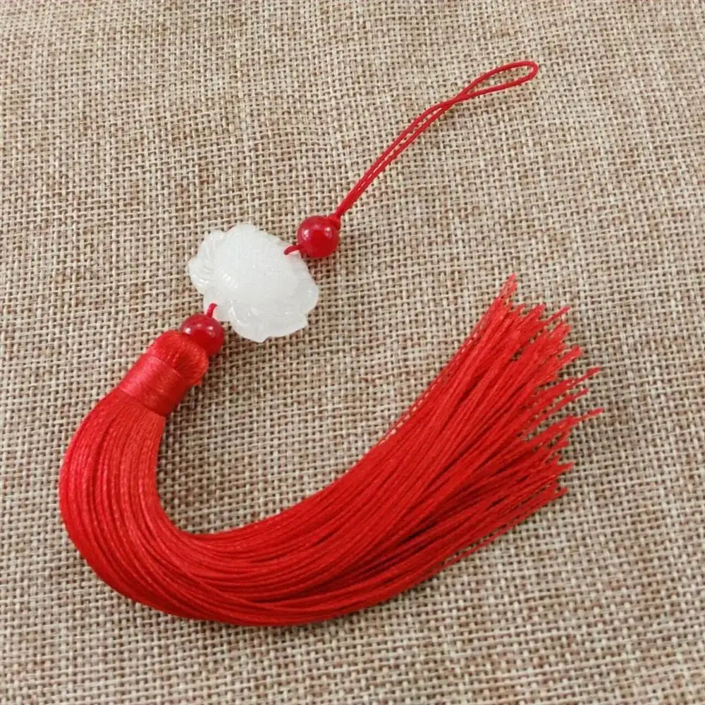 A red silk tassel decorative pendant with a white jade lotus pendant and two small red beads for living room decor