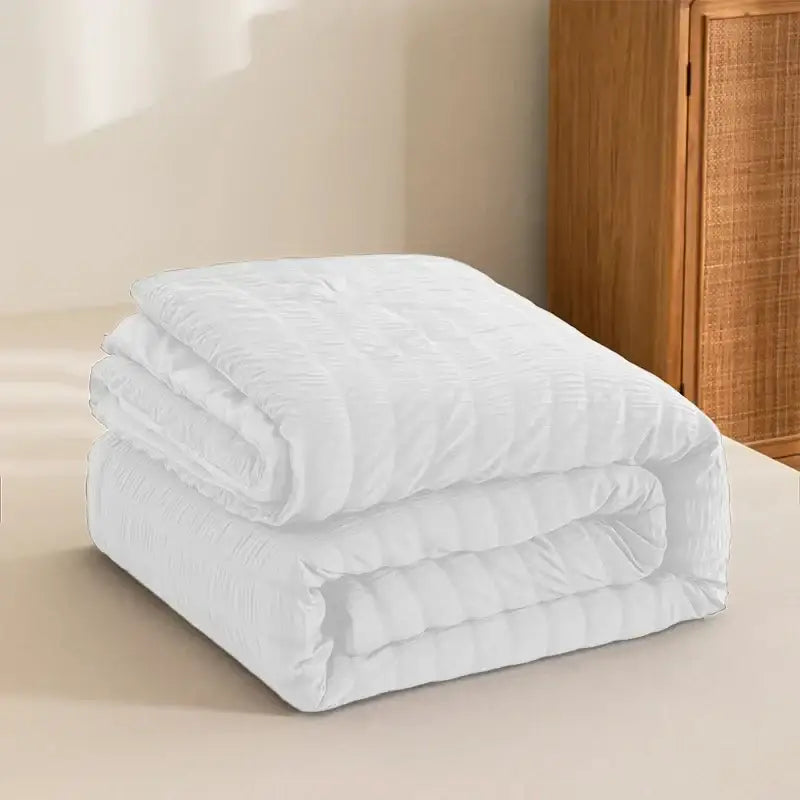 White king size seersucker quilt with soft textured surface and subtle vertical stitching for all season comfort