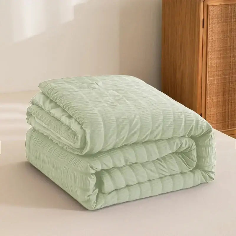 A soft light green seersucker quilt with subtle texture for decorbites king size all season comforter use