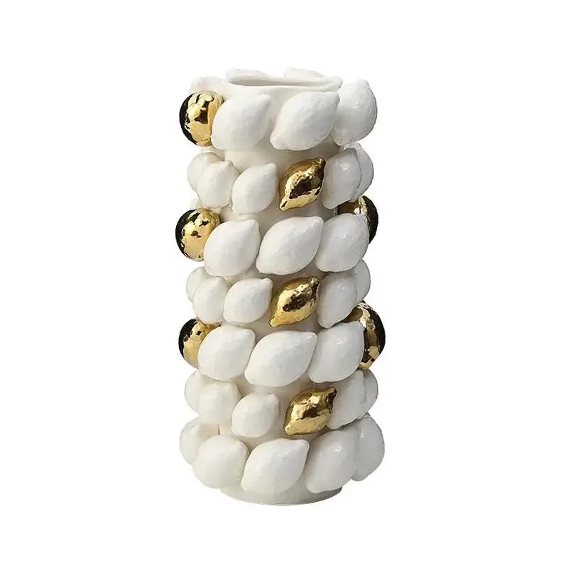 White ceramic vase with textured shell-like protrusions and gold black spheres in lemon carambola design for living room decor