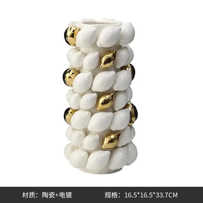 White ceramic vase with gold leaf accents and textured shell-like lemon carambola design for living room decor