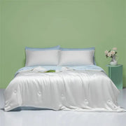 White satin duvet cover with subtle button detailing and light blue pillowcases in decorbites cool feel summer quilt bedroom