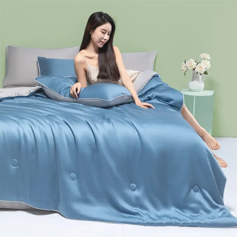 Blue satin decorbites cool feel summer quilt with subtle quilted button details for a cool feel summer bedroom