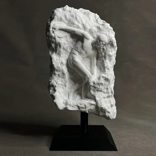 White marble discus throwing nude sculpture in dynamic pose carved into rugged rock for home decor in living room