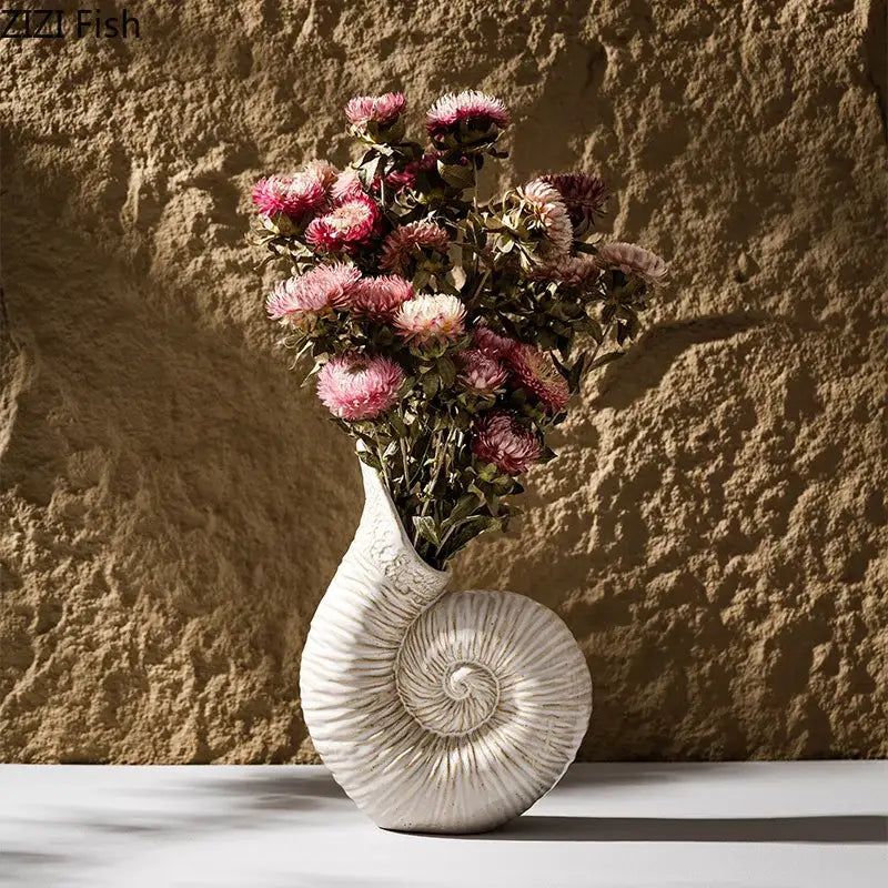 White nautilus conch ceramic vase from decorbites holding dried pink and purple flowers for bedroom and office decor