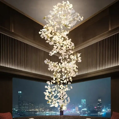 A cascading white orchid decorbites ginkgo chandelier with gold stems suspended above a cityscape living room pendant light