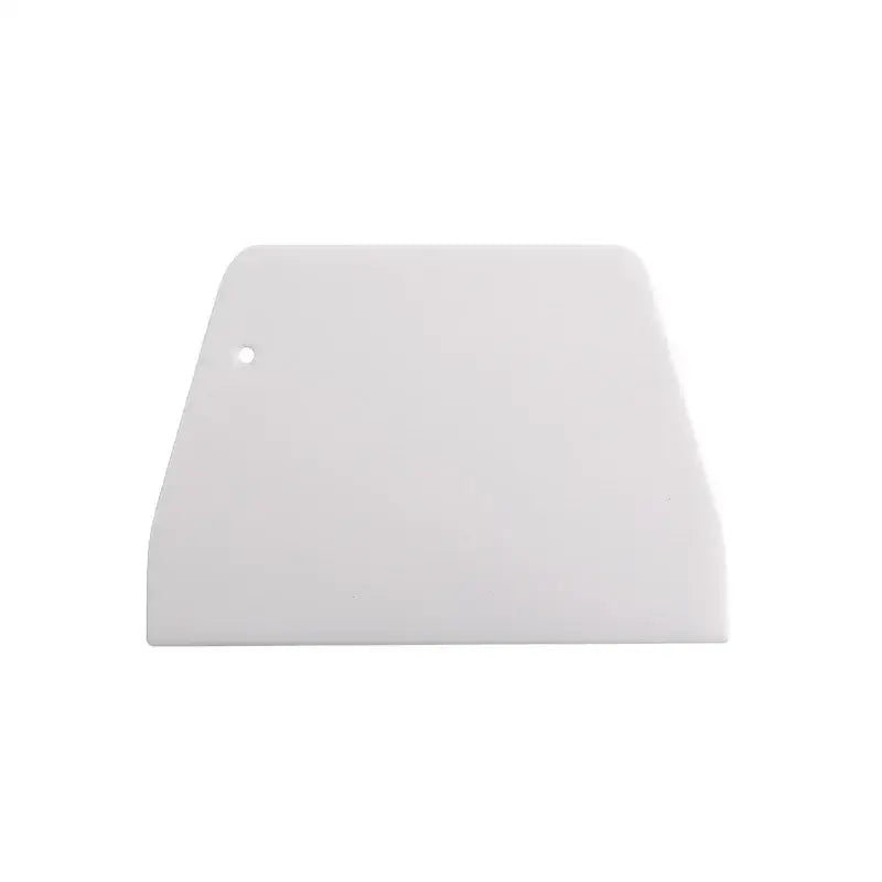 White plastic dough cream cake cutter spatula with rounded top edge and small hole for kitchen baking use