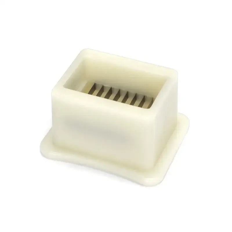 Off-white plastic rectangular green bean slicer with a grid of metal blades for kitchen vegetable shredding
