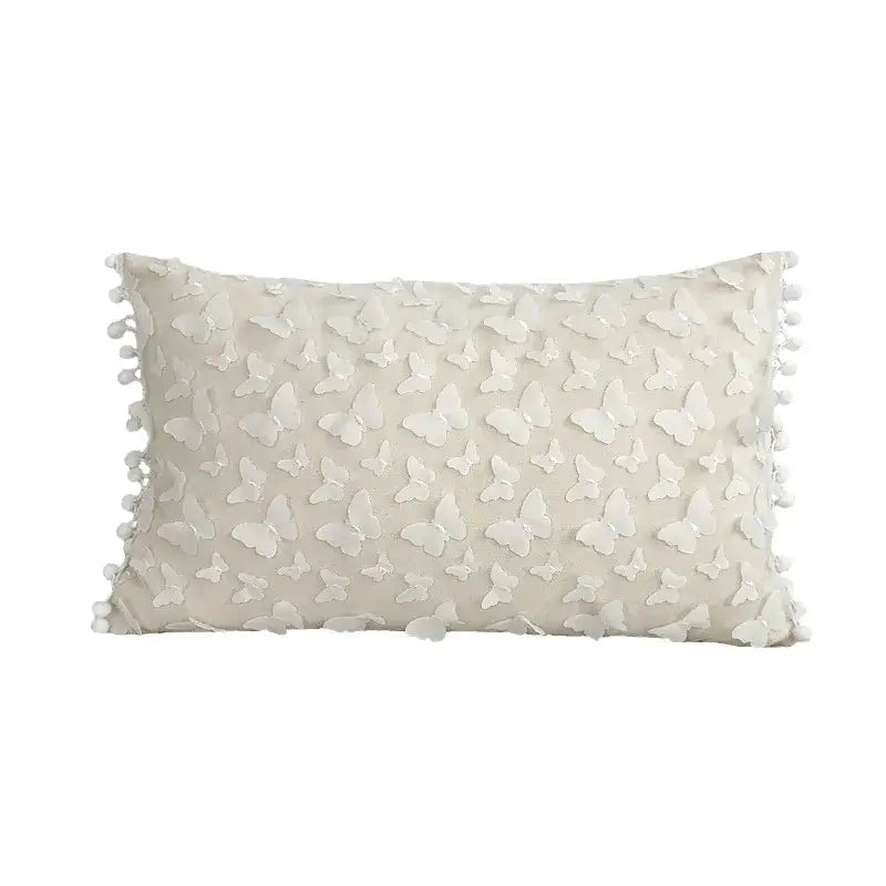 Cream-colored cushion cover with raised white plum blossom butterfly appliqués and pom-pom trim for decorbites 3d plum decor