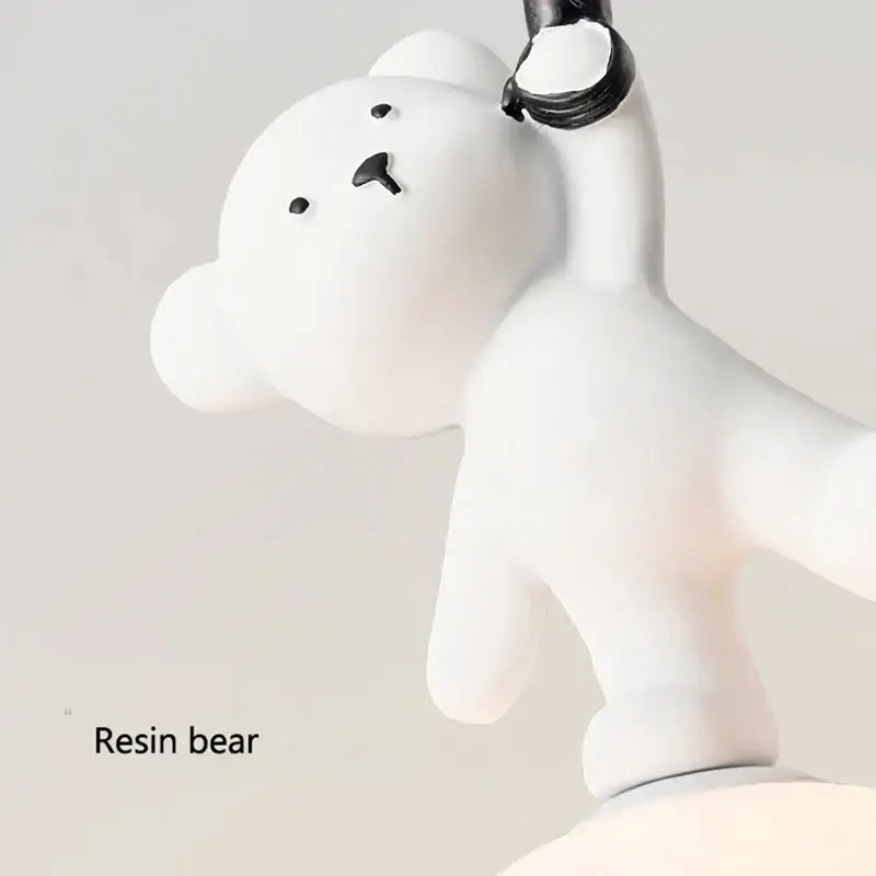 White resin bear pendant lamp with black eyes holding a small black object for nursery room bear nursery room decor