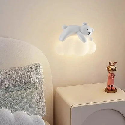 A soft white polar bear figurine rests on a warm glowing cloud led wall lamp for childrens bedroom bear led wall light