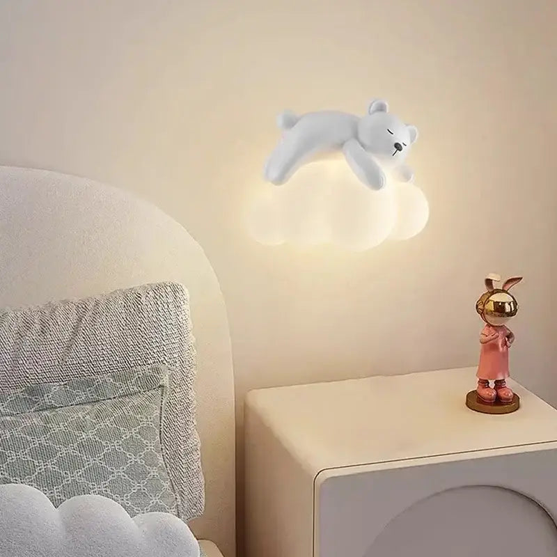 A soft white polar bear figurine rests on a warm glowing cloud led wall lamp for childrens bedroom bear led wall light