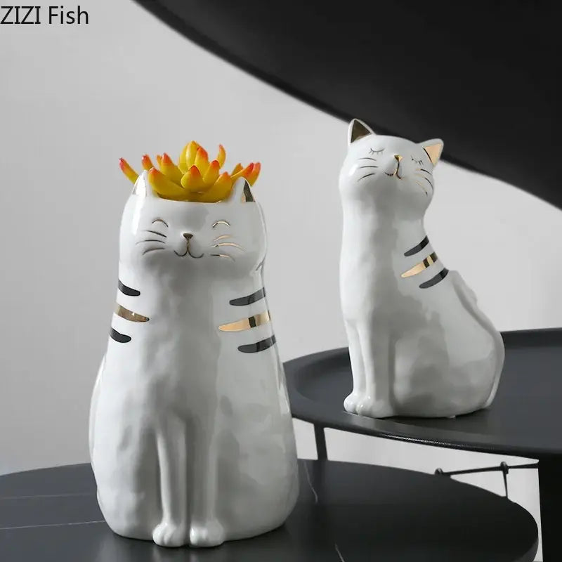 White porcelain decorbites cat vase with gold trim holding a yellow-orange succulent for living room decor