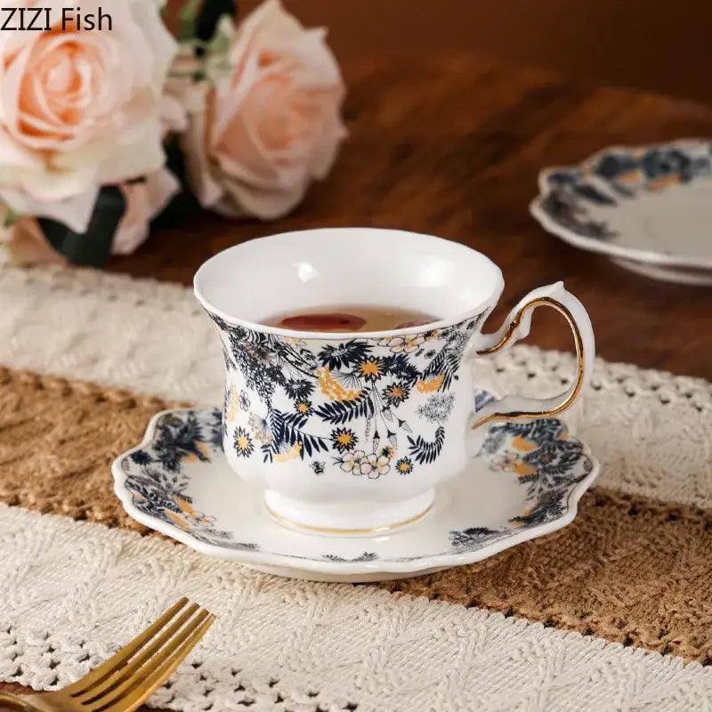White porcelain classic tea cup set with navy blue and gold floral pattern and a scalloped porcelain classic coffee saucer