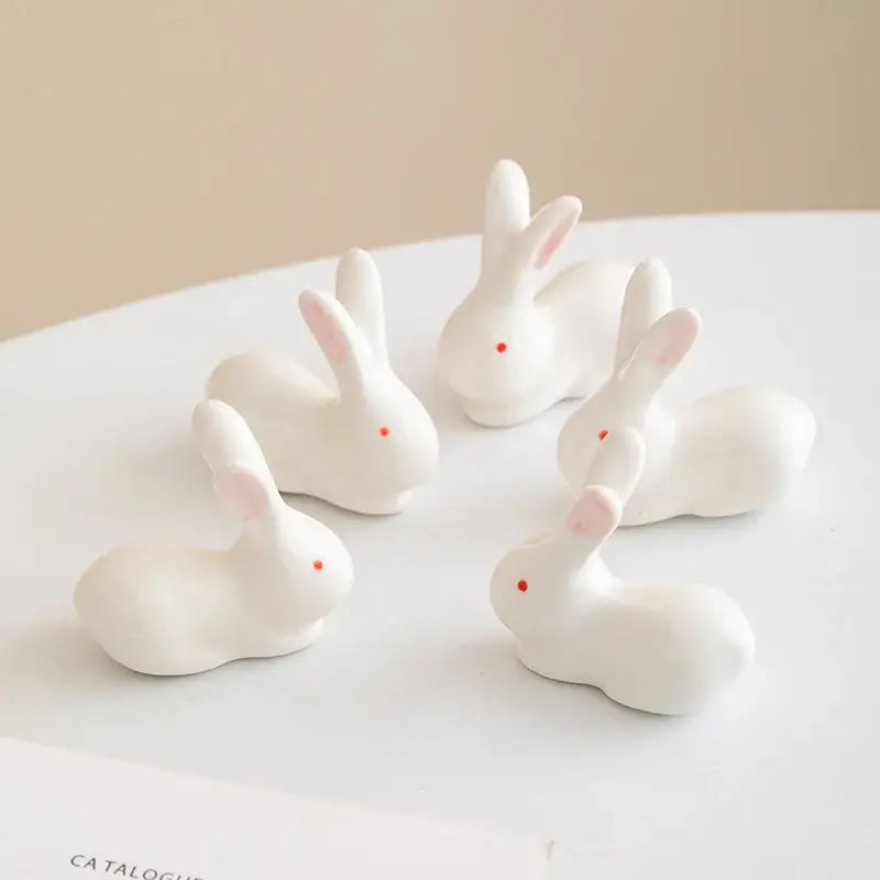 White porcelain duck chopstick holder tray featuring white ceramic bunny figurines with pink ears and red dot eyes