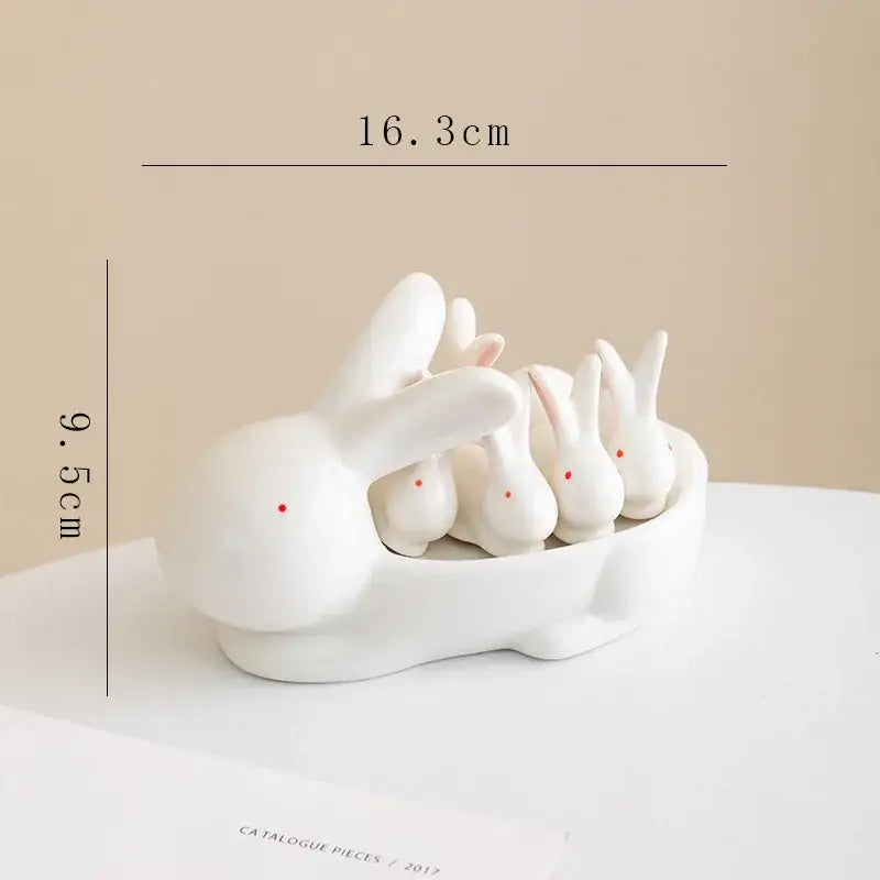 White porcelain ceramic chopstick holder tray featuring a duck design and a white ceramic rabbit figurine set with red eyes