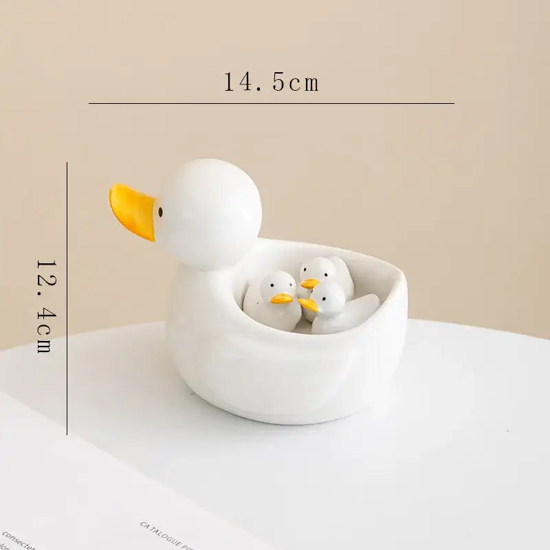 White porcelain duck chopstick holder tray featuring a white ceramic duck with three smaller ducklings and yellow beaks