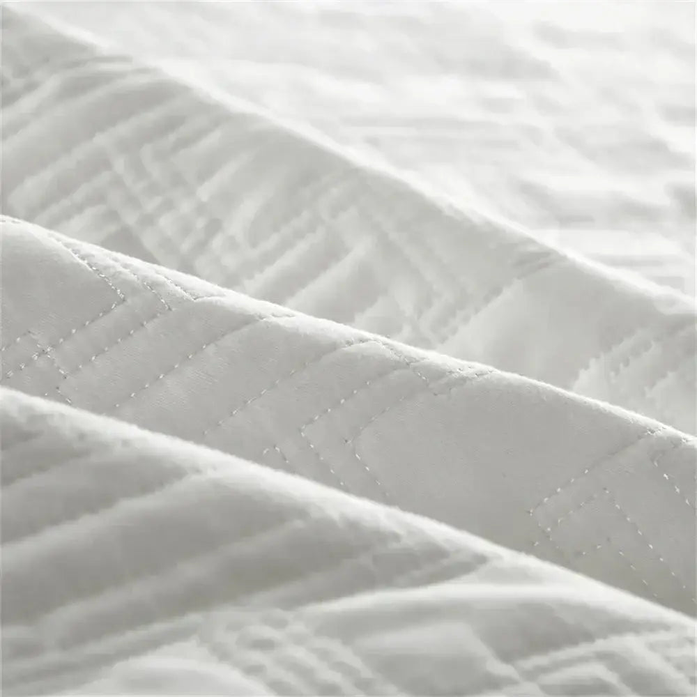 White quilted cotton coverlet bedspread set with subtle textured pattern and fine stitching for bedroom decorbites decor