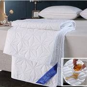 White quilted bed protector pad with geometric star pattern and stitched detailing for bedroom use