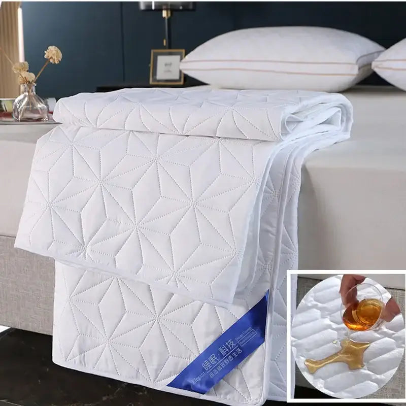 White quilted bed protector pad with geometric star pattern and stitched detailing for bedroom use