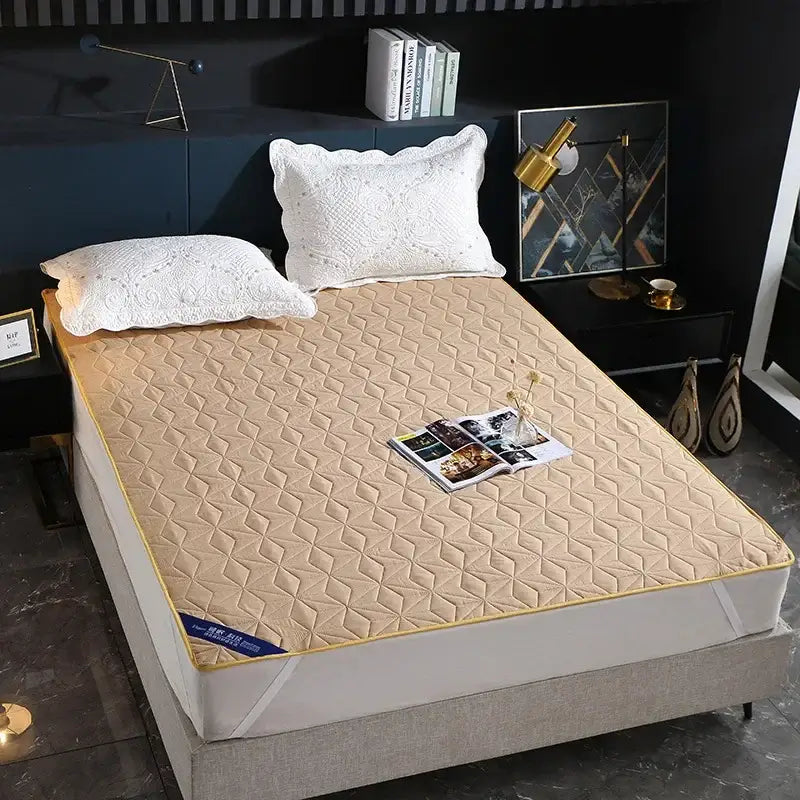 Beige quilted bed protector pad with yellow border and diamond pattern stitching for bedroom use
