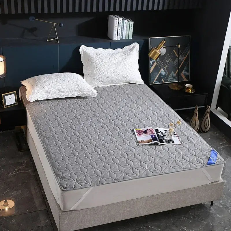 Gray quilted bed protector pad with geometric diamond pattern offering waterproof protection for bedrooms