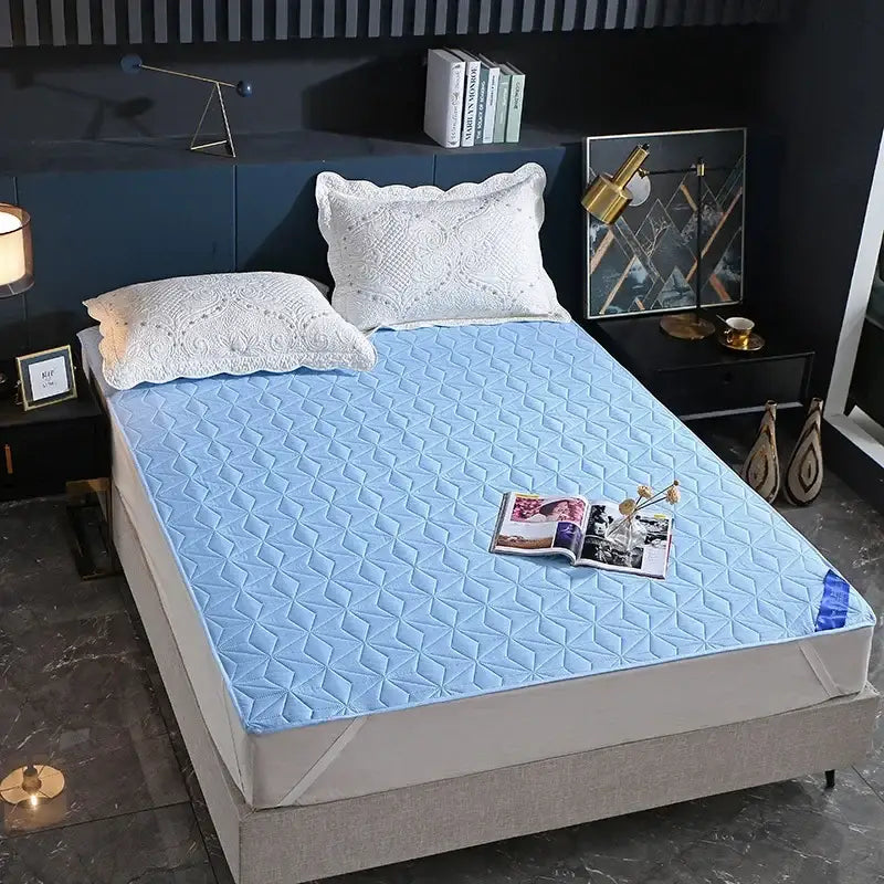 Light blue quilted bed protector pad with diamond pattern designed as a waterproof bed protector for bedrooms