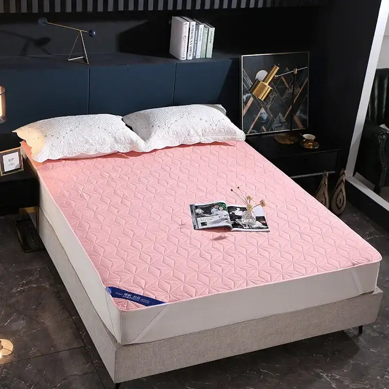 Pink quilted mattress pad with geometric diamond pattern used as a bed protector pad in bedroom settings