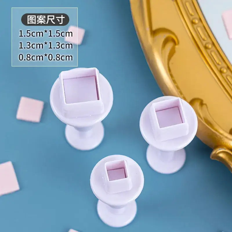 White plastic square-shaped cake decorating cookie cutters with small red heart and star interiors for cake decorating