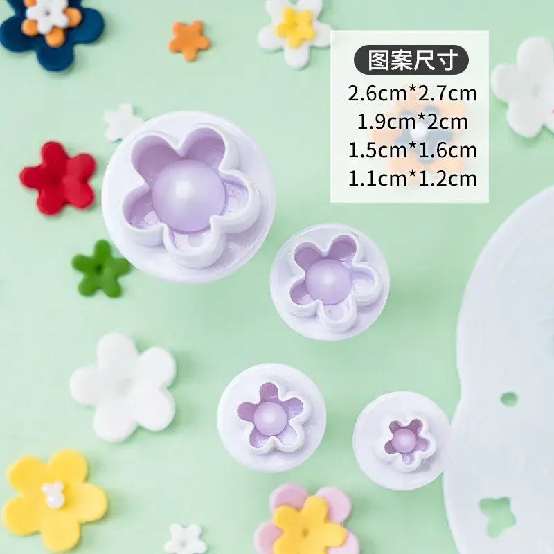 Set of five white flower-shaped cake decorating cookie cutters with lavender centers for star cake decorating