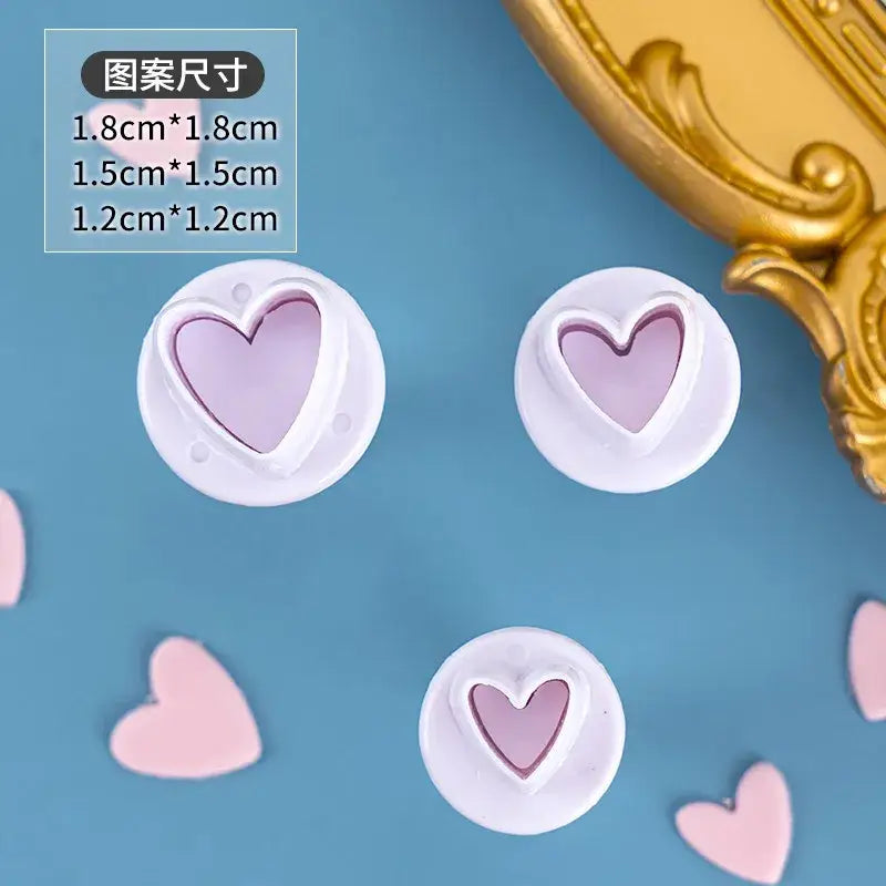 White heart-shaped cake decorating cookie cutters in three sizes with translucent lavender interiors for star cake decorating