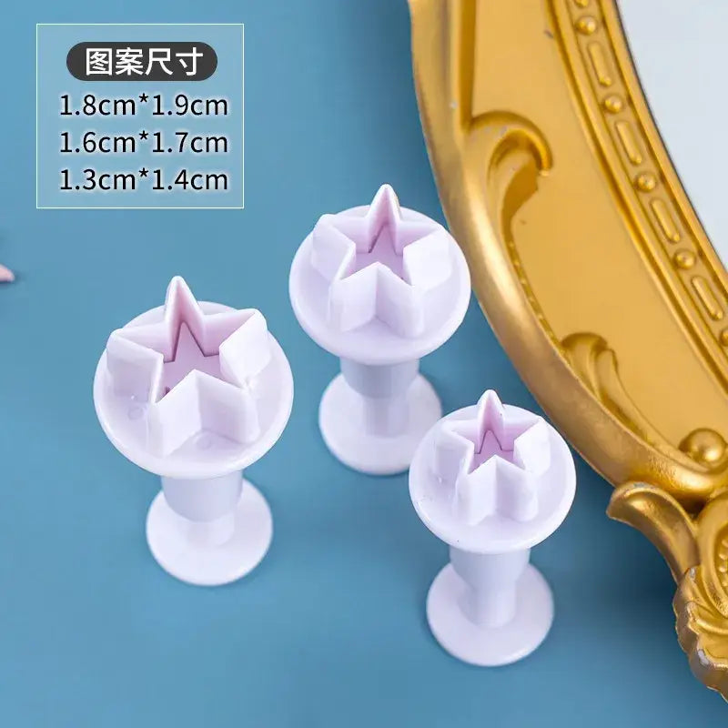 Set of three white plastic star cake decorating stampers with subtle lavender interior for cake decorating cookie use