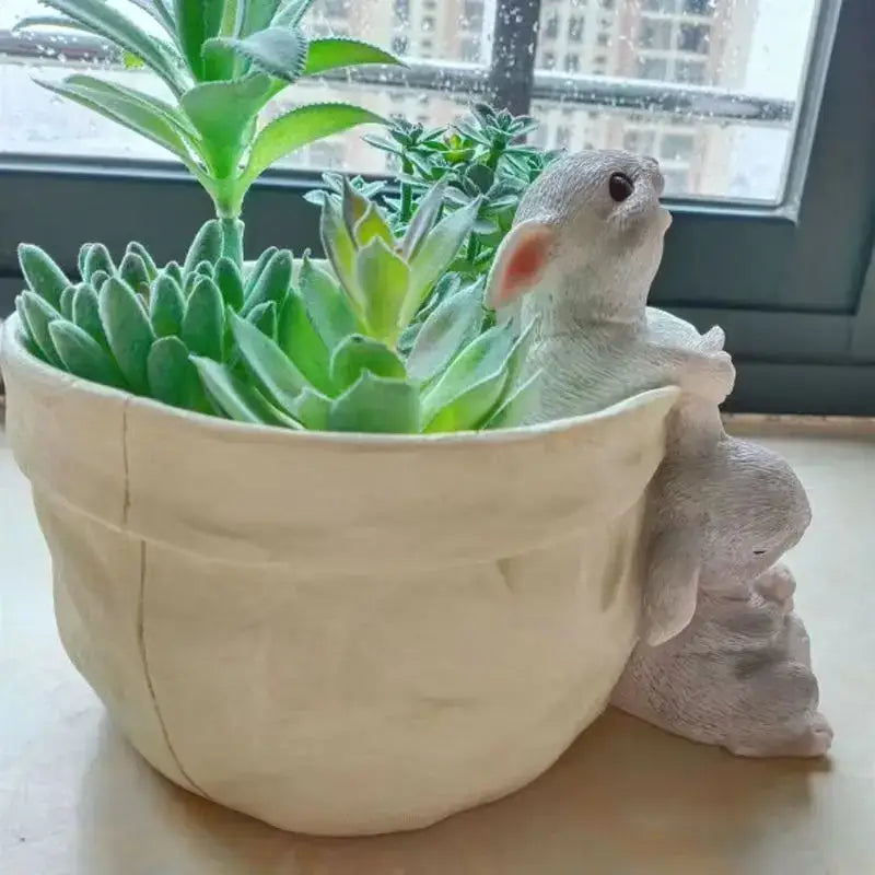 Beige fabric succulent planter pot with a white resin bunny decorbites bunny succulent holding vibrant green succulents