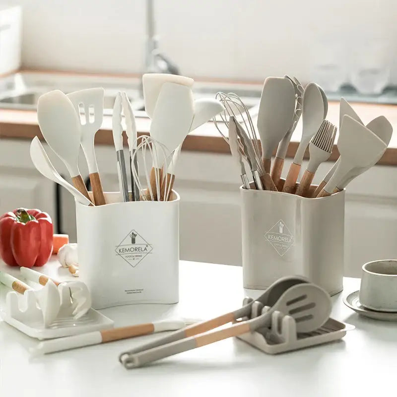 White ceramic kitchen utensil organizer with wooden handles and diamond shaped kemorela logo for silicone kitchen cookware set